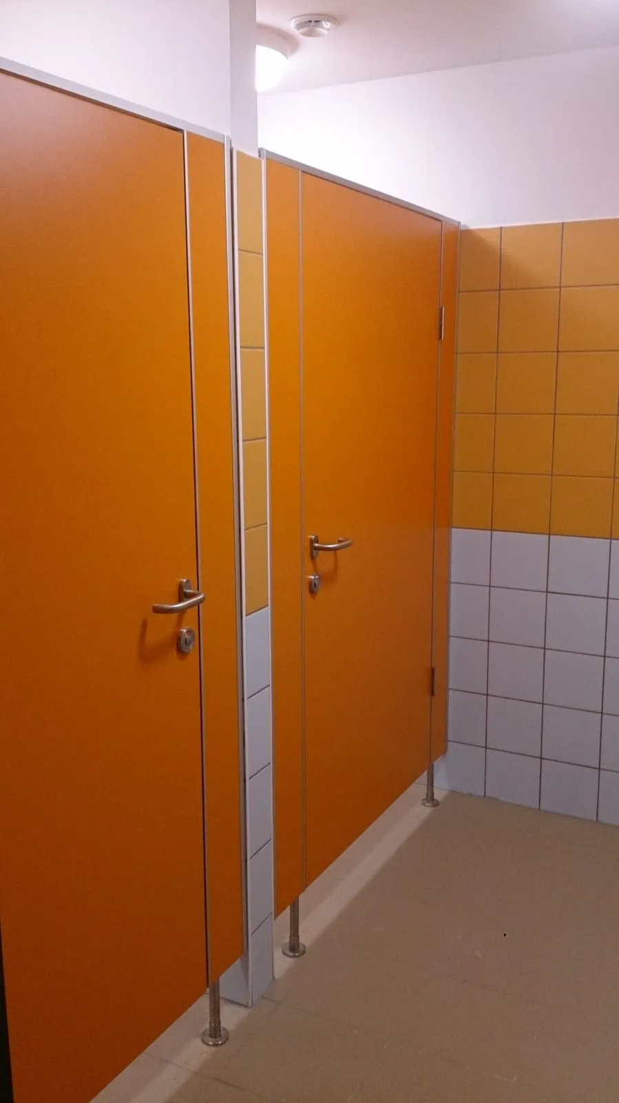 Pomarańczowe obniżone kabiny sanitarne dla przedszkola